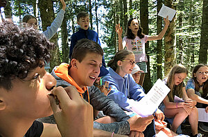Un groupe d'enfant en train de discuter et jouer en forêt.