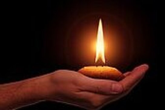 main tenant une bougie allumée