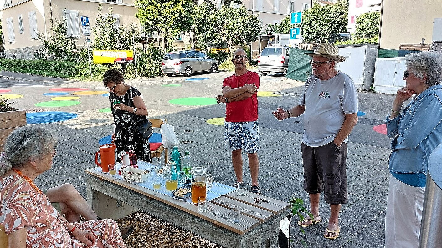 Un groupe de personnes discute lors d'un apero devant le temple