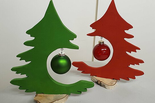 Deux petits sapin découpé dans du bois, avec une boule de Noël