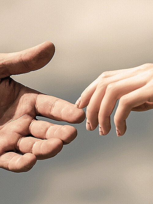 Hands of man and woman on blue sky background. Giving a helping hand. Lending a helping hand. Solidarity, compassion, and charity, rescue.