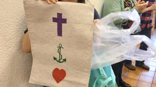 les paroissiens de Villeneuve et le Conseil paroissial ont brodé un tissu avec la crois, l'ancre et un coeur à l'intention du groupe de jeunes qui le transmettra à la paroisse d'Aigle