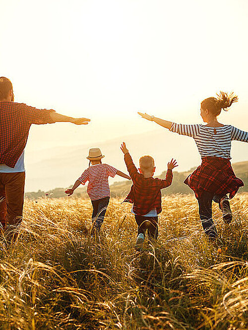 Happy family: mother, father, children son and daughter on nature on sunset