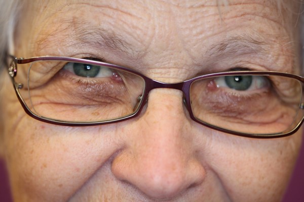 Regard d'une femme âgée porteuse de lunettes.