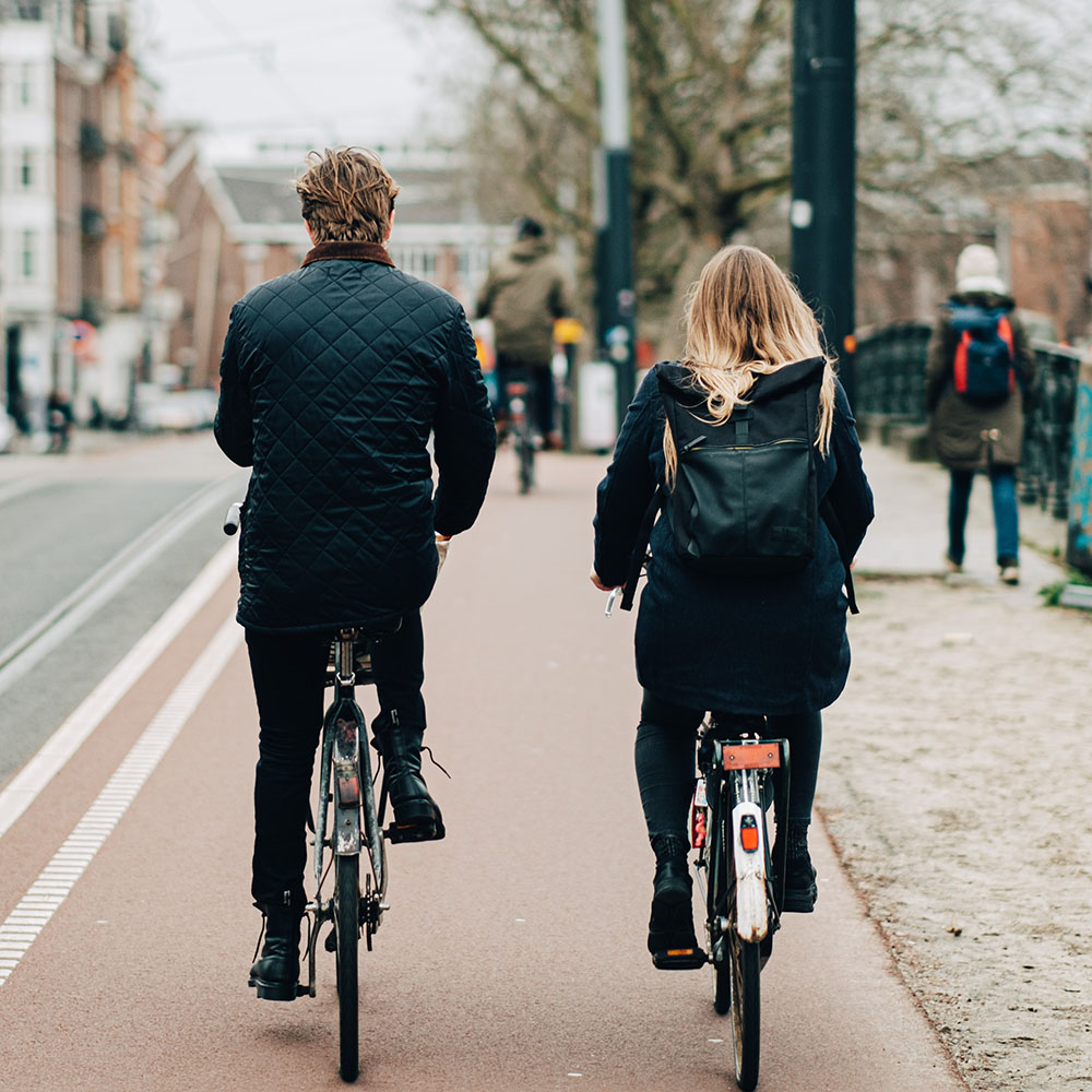 Un homme et une femme en train de faire du vélo dans un environnement urbain.