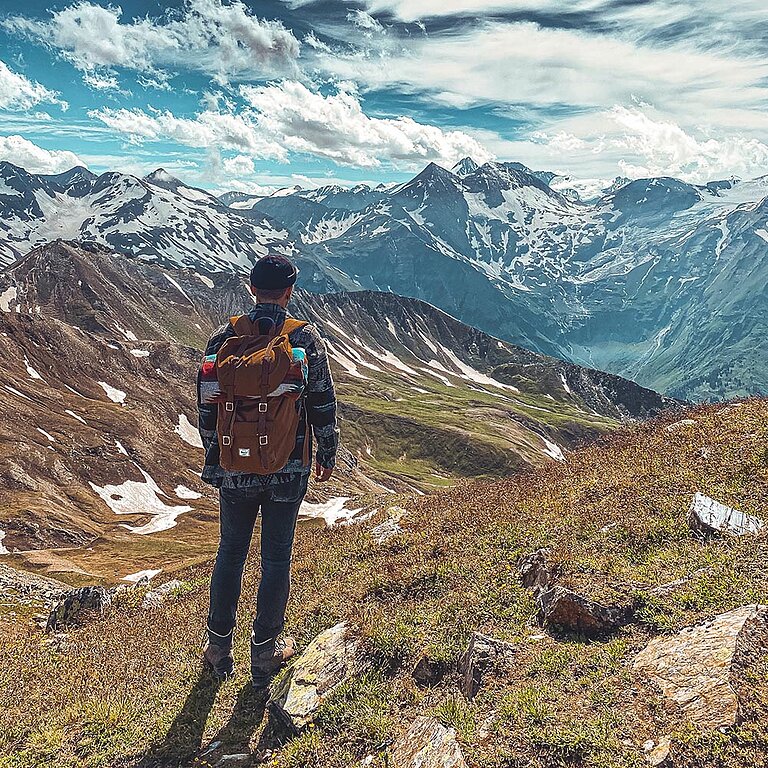 Un homme contemple le paysage en montagne.