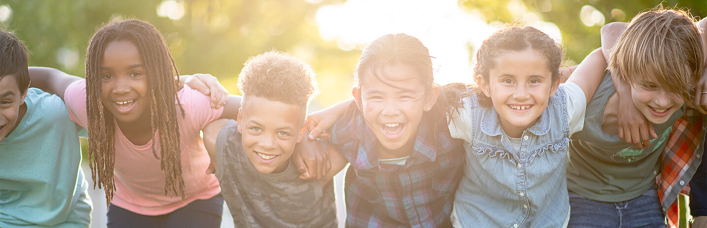 1295132350 Petit groupe de jeunes souriant au soleil.