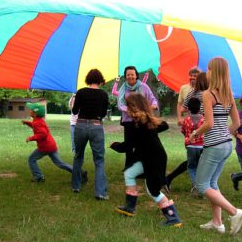 Enfants s'amusant sous un foulard coloré géant